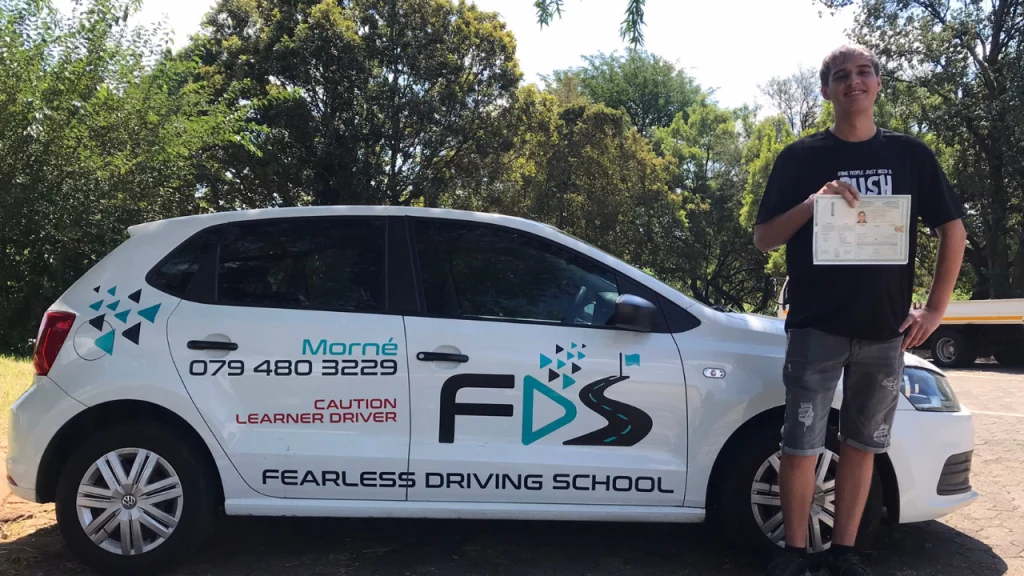 A Fearless student celebrating beside the school's car